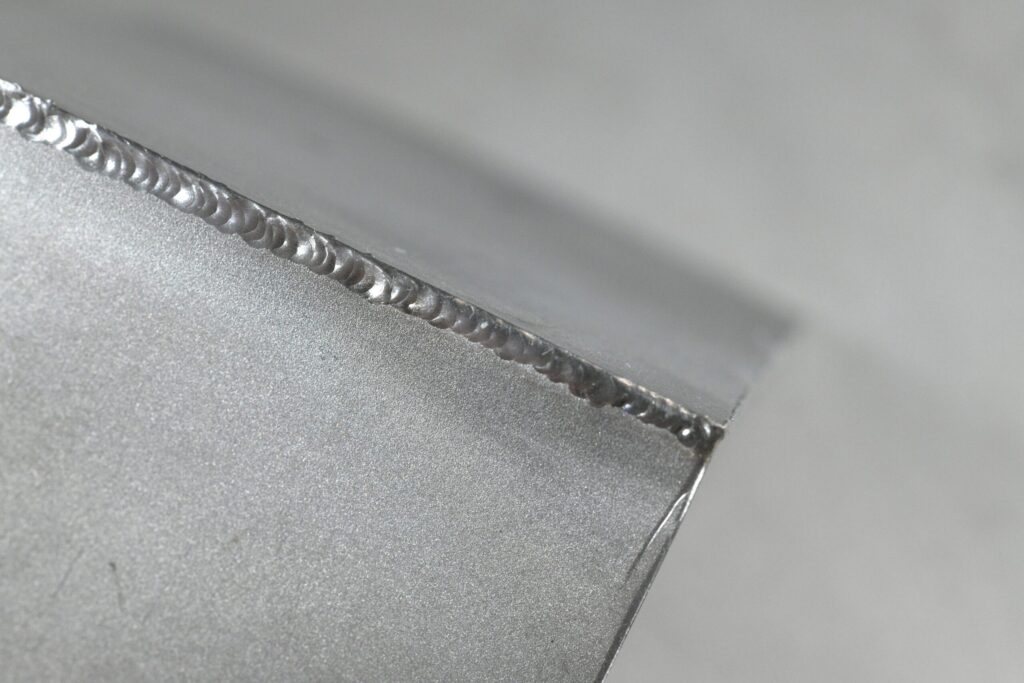 A fine micro-TIG weld seam set spot by spot along a thin sheet edge
